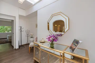 a living room with a mirror and a vase of flowers at The Heritage 4BR Villa Luxury Oasis in Canggu