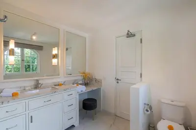 a bathroom with a sink and a mirror and a toilet at The Heritage 4BR Villa Luxury Oasis in Canggu