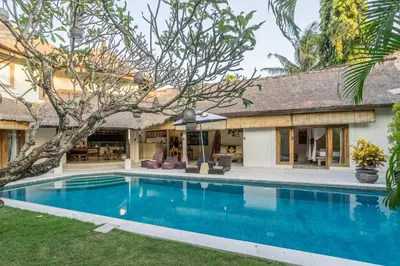 a swimming pool in front of a house at Villa Umah Maya in Seminyak