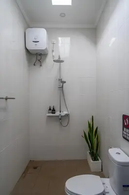 a white bathroom with a toilet and a sink at The Kakadu - A new modern 2BR Villa with private pool in Seminyak in Seminyak