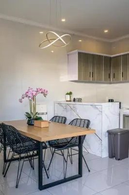 a kitchen with a wooden table and chairs at The Kakadu - A new modern 2BR Villa with private pool in Seminyak in Seminyak