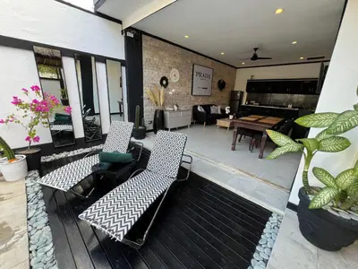 a patio with two chairs and a table and a table at Villa Mawar Seminyak in Seminyak