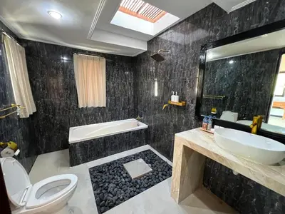 a bathroom with a sink and a tub and a toilet at Villa Mawar Seminyak in Seminyak