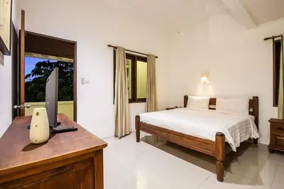 a bedroom with a bed and a computer on a desk at Putri Bali Seminyak Villa in Seminyak