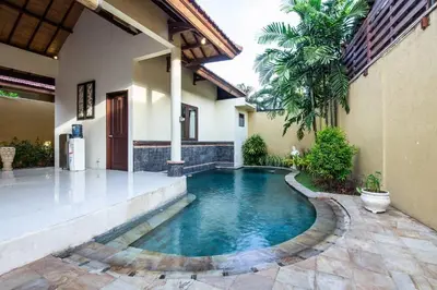 a swimming pool in the courtyard of a house at Putri Bali Seminyak Villa in Seminyak