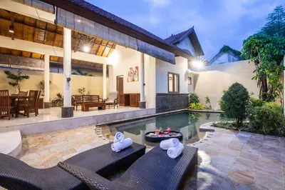 a villa with a swimming pool and a house at Putri Bali Seminyak Villa in Seminyak