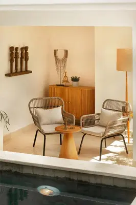 two chairs and a table next to a swimming pool at Balidroomvilla Sanur Mangrove - Full Serviced - Beachside in Sanur