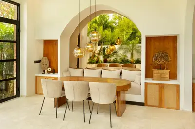 a dining room with a wooden table and chairs at Balidroomvilla Sanur Mangrove - Full Serviced - Beachside in Sanur