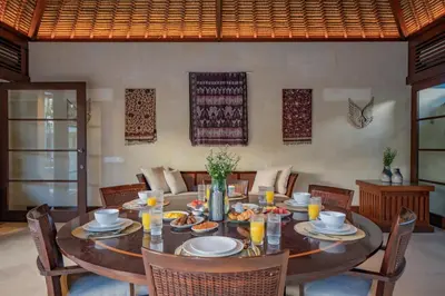 a dining room with a wooden table and chairs at Villa Wibisana Beachside Luxury in Seminyak in Seminyak
