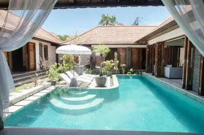 a swimming pool in the backyard of a house at Beachside Villa Di Bucu in Canggu