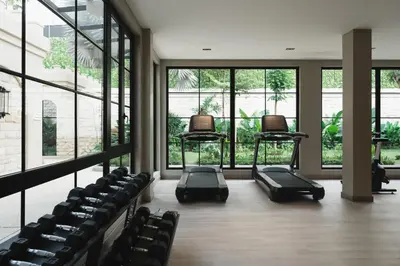 an empty gym with two chairs in front of windows at Hygge Hotel and Villas Seminyak in Seminyak
