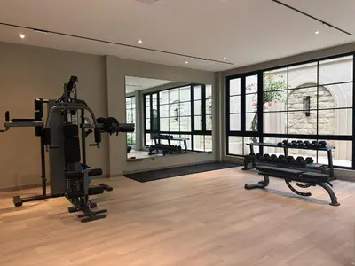 a gym with two treadmills and weights in a room at Hygge Hotel and Villas Seminyak in Seminyak
