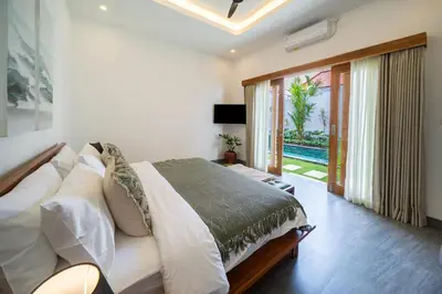 a bedroom with a bed and a sliding glass door at Villa Mailaku Seminyak in Seminyak