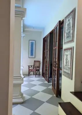a hallway with a checkered floor and wooden doors at Villa Seni in Seminyak
