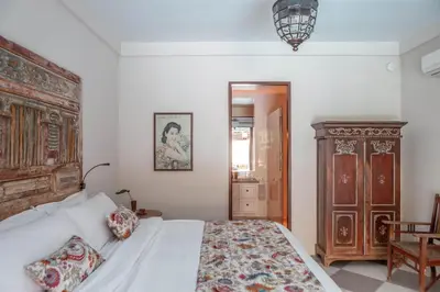 a bedroom with a bed and a wooden cabinet at Villa Seni in Seminyak