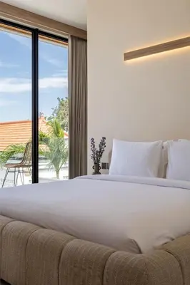 a bedroom with a large bed and a large window at Villa Oasia 2 Seminyak in Seminyak