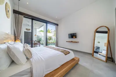 a bedroom with a large bed and a large window at Peaceful 2BR Pool Villa in Kerobokan - V2 in Kerobokan