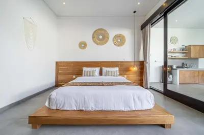 a bedroom with a large bed with a wooden headboard at Peaceful 2BR Pool Villa in Kerobokan - V2 in Kerobokan