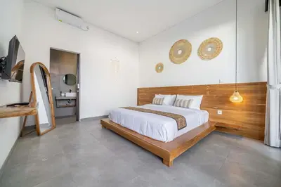 a bedroom with a large bed with a wooden headboard at Peaceful 2BR Pool Villa in Kerobokan - V1 in Kerobokan