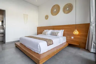 a bedroom with a large bed and a clock on the wall at Peaceful 2BR Pool Villa in Kerobokan - V1 in Kerobokan