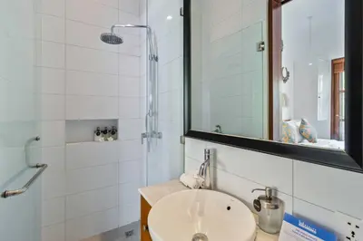 a bathroom with a sink and a shower and a mirror at Perfect for Couples and Solo Travellers in Seminyak