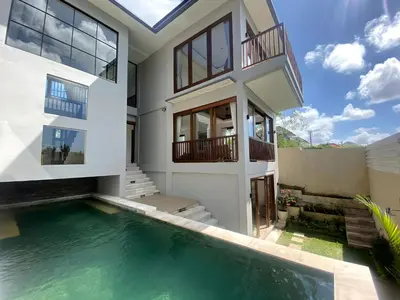 a house with a swimming pool in front of it at SummerVille Nusa Dua by REJA Villas in Nusa Dua