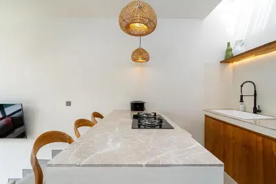 a kitchen with a table with chairs and a sink at Villa Grace&Glory-2 bedroom villa near Canggu in Kerobokan