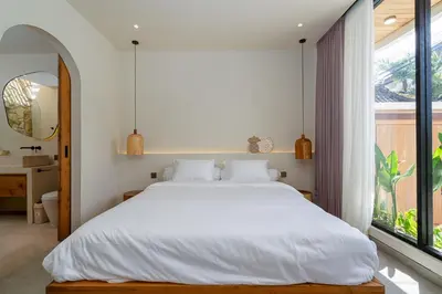 a bedroom with a white bed and a large window at Villa Grace&Glory-2 bedroom villa near Canggu in Kerobokan