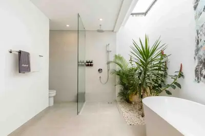 a bathroom with a glass shower and a toilet at Nature's Immersion Room at Anwa Bali Boutique Resort in Canggu
