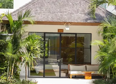 an open door to a house with palm trees at Stunning Garden Room with Private Pool at Anwa Bali in Canggu