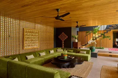 a living room with a green couch and a table at The Riverfront 5BR Luxury Villa Near the Beach in Canggu