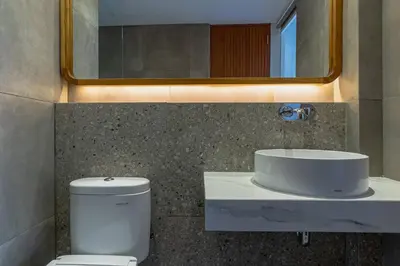 a bathroom with a toilet and a sink and a mirror at LOI Mansion Managed by ARM One Hundred in Seminyak