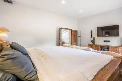 a large bed in a living room with a television at Villa CC- Cosy 2bdrs villa - enclosed and open living area in Seminyak