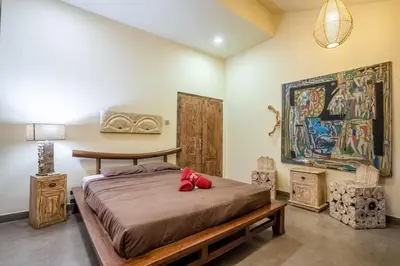 a bedroom with a bed and a painting on the wall at Villa CC- Cosy 2bdrs villa - enclosed and open living area in Seminyak