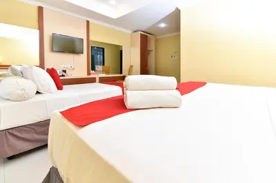 a hotel room with two beds and a tv at RedDoorz Plus near Mall Bali Galeria 2 in Denpasar