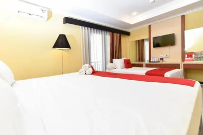 a hotel room with two beds and a television at RedDoorz Plus near Mall Bali Galeria 2 in Denpasar