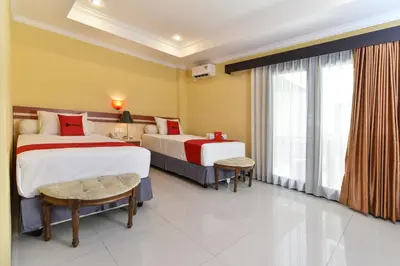 a hotel room with two beds and a window at RedDoorz Plus near Mall Bali Galeria 2 in Denpasar