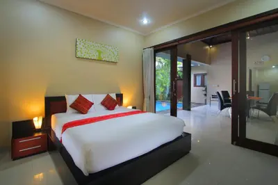 a bedroom with a bed and a sliding glass door at Lotus Tirta Seminyak in Seminyak