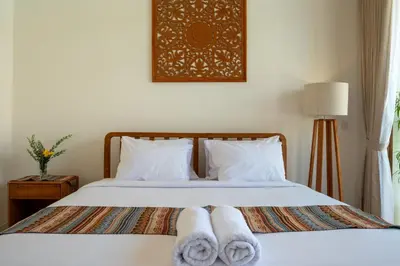 a bedroom with a bed with towels on it at Comoda Seminyak in Seminyak