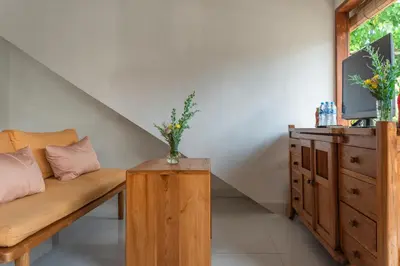 a living room with a couch and a dresser at Comoda Seminyak in Seminyak