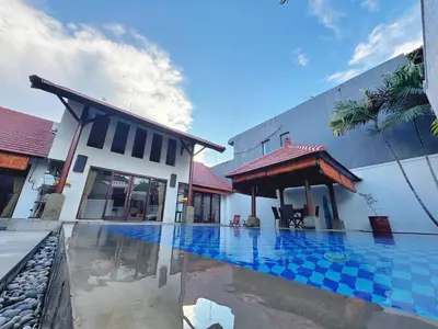 a villa with a swimming pool next to a building at Brady's 3 bedrooms Villa Center of Sanur in Sanur
