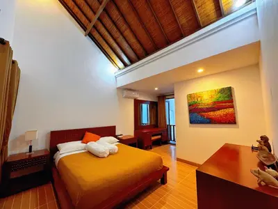 a bedroom with a bed and a painting on the wall at Brady's 3 bedrooms Villa Center of Sanur in Sanur