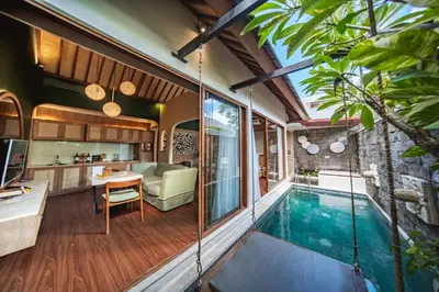 an indoor pool in a house with a living room and kitchen at Ini Vie Villa Seminyak by Ini Vie Hospitality in Legian