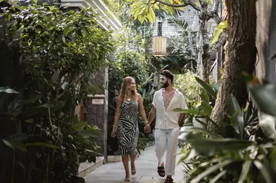 a man and a woman walking down a path at Ini Vie Villa Seminyak by Ini Vie Hospitality in Legian