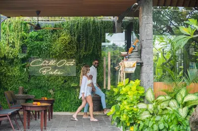 a man and woman walking in front of a garden cafe at Ini Vie Villa Seminyak by Ini Vie Hospitality in Legian