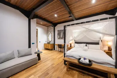 a bedroom with a canopy bed and a couch at 4 Bedrooms Brand New serenity Villa in Seminyak