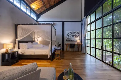 a bedroom with a canopy bed in a room with windows at 4 Bedrooms Brand New serenity Villa in Seminyak