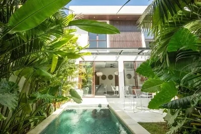 an indoor pool in a garden with plants at Chic Modern 3BR Villa, Enclosed Living Room in Canggu