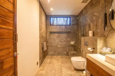 a bathroom with a toilet and a sink at Chic Modern 3BR Villa, Enclosed Living Room in Canggu
