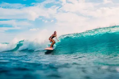 a man riding a wave on a surfboard in the ocean at SC Hotel - 1 Minute to the Beach By Micky Studio in Badung